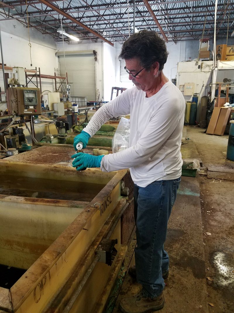Worker in gloves at a plating tank