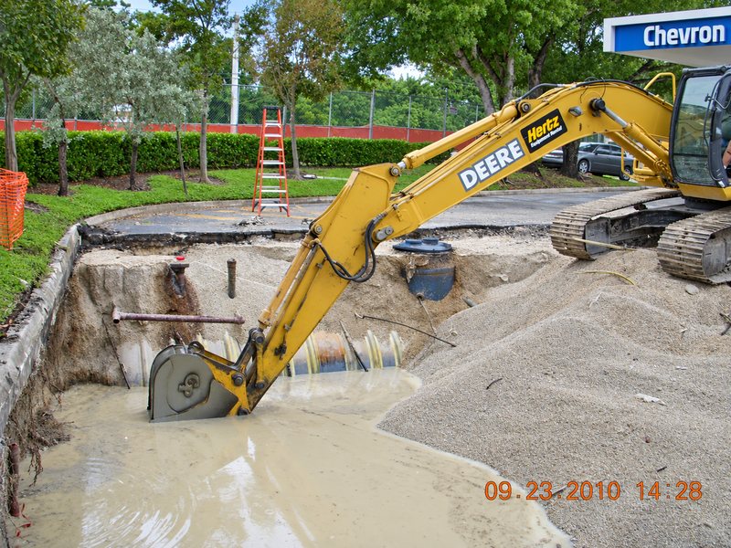 Excavator digging a pit with groundwater