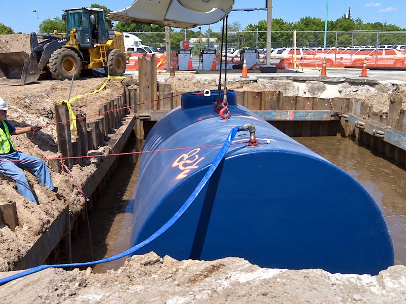 New blue tank being installed in the excavation