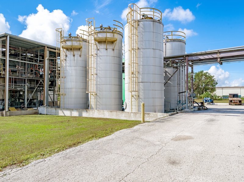 Row of tall storage tanks beside a building